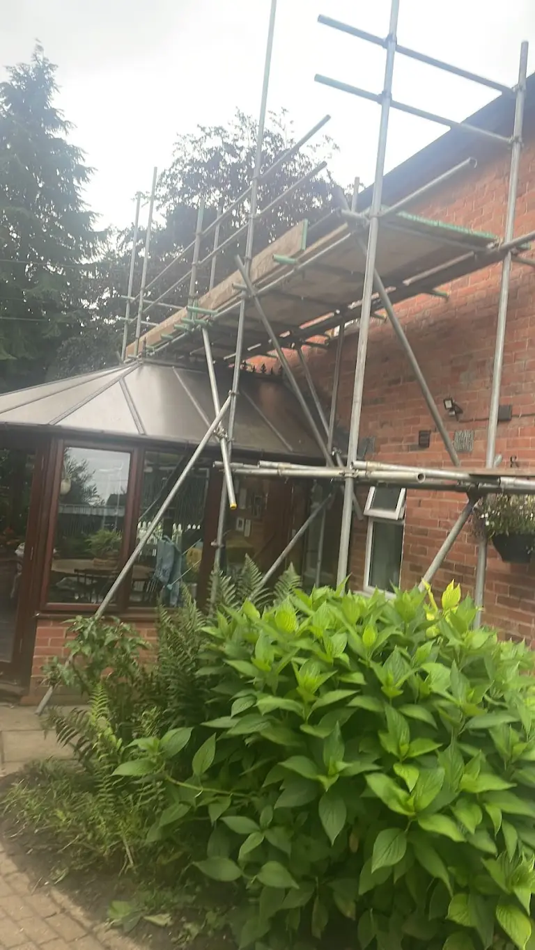 House exterior under scaffolding during painting and decorating project