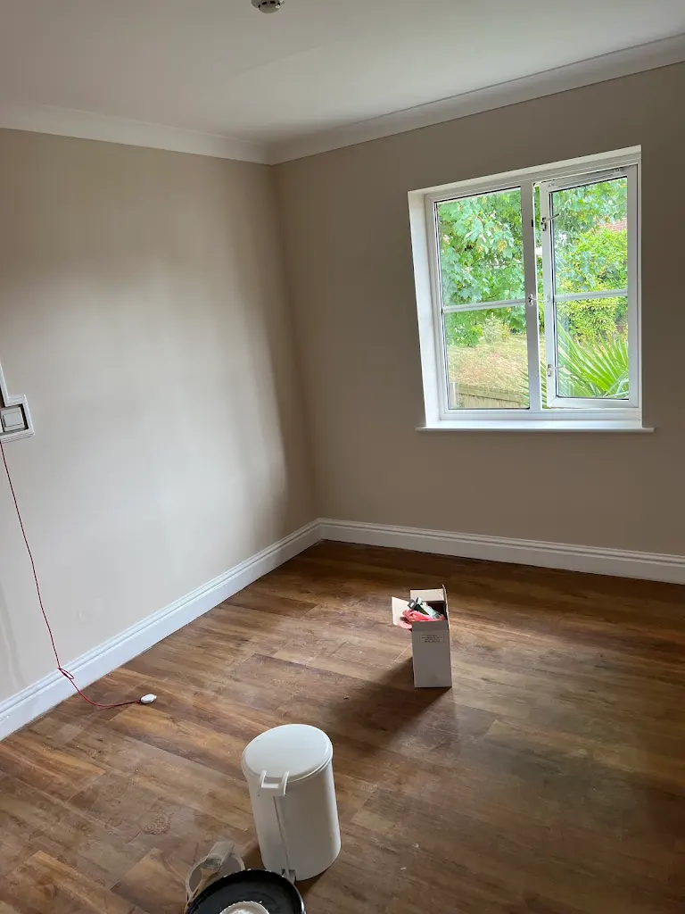 Empty room with freshly painted walls and wooden flooring, clean modern look