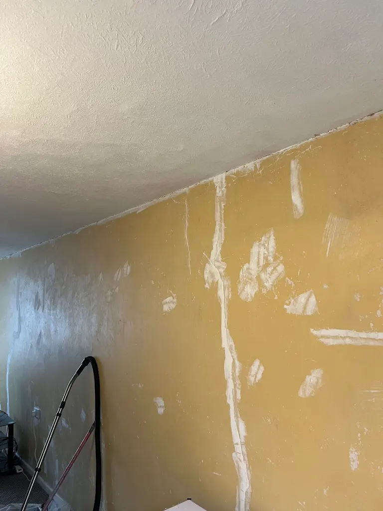 Yellow interior wall with filler patches during preparation, ready for painting and decorating work