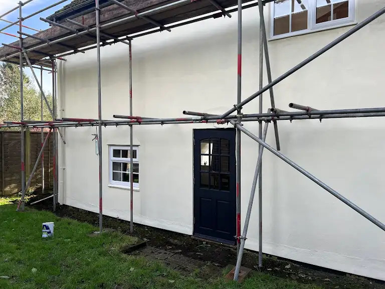 Exterior house painting with scaffolding setup, professional decorating in progress