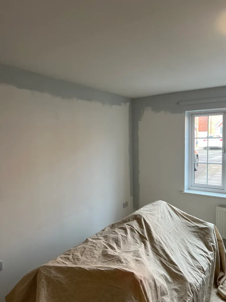 Empty room with freshly painted white walls and green carpet, clean residential interior finish