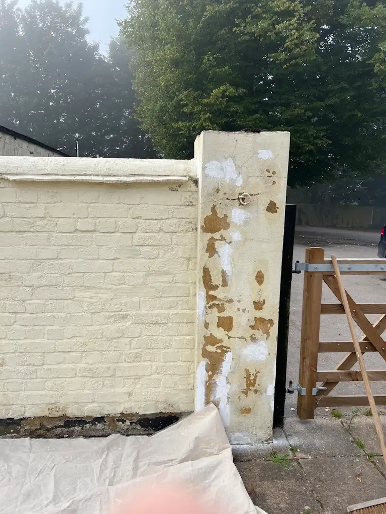 Painted garden wall with clean cream coating and repaired surface