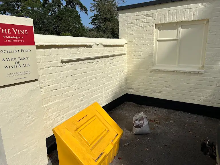 Outdoor painted wall corner with tidy finish and bin area